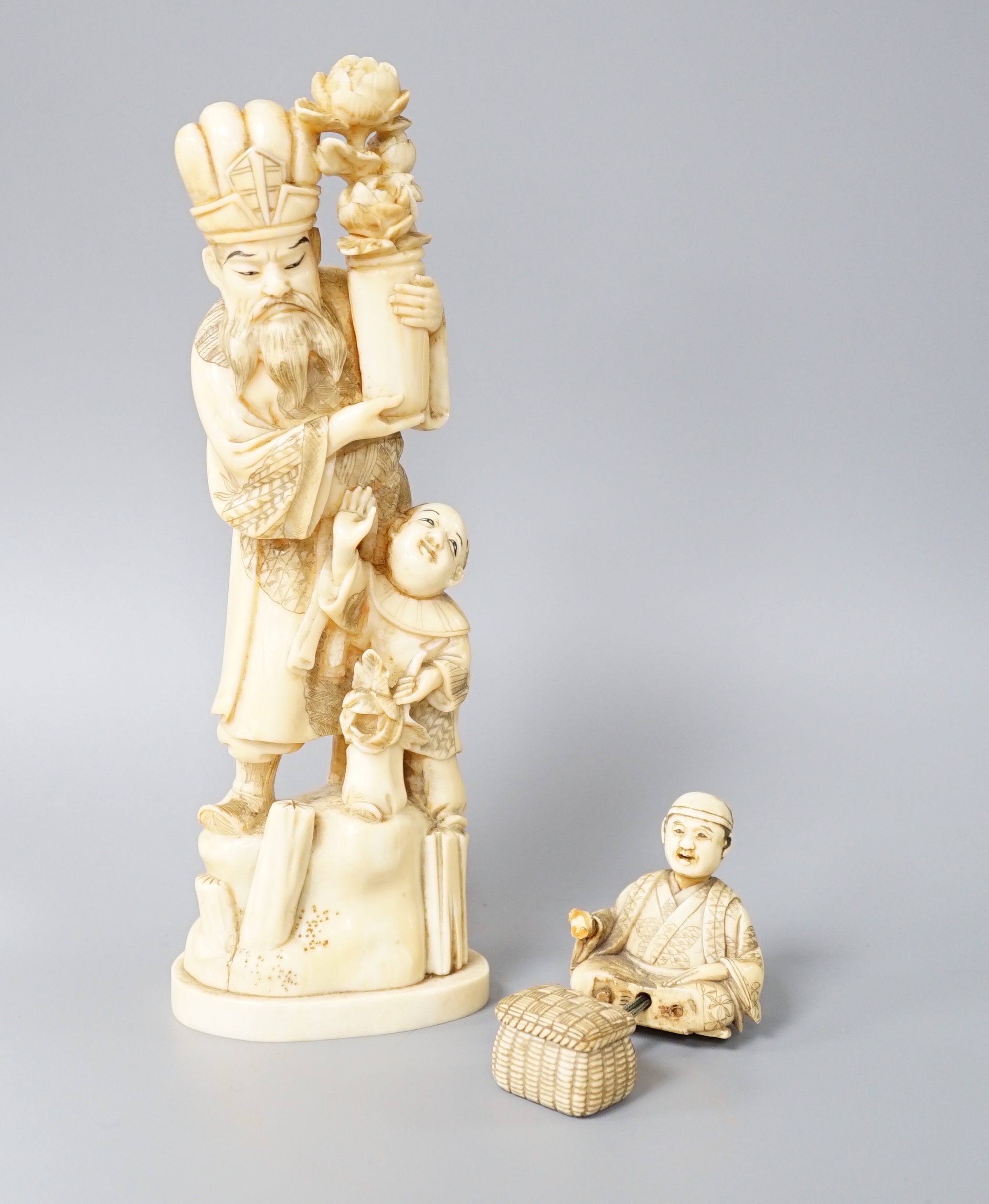 A 19th century Japanese marine ivory okimono of a bearded man and child together with a similar ivory okimono of a mask seller. Tallest 21cm